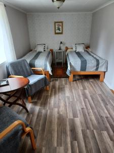 Habitación con 2 camas, sofá y mesa. en Kopparhyttan1 en Valdemarsvik