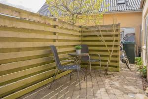 un patio con 2 sillas y una mesa frente a una valla en Grindsted - Billund Apartment 1, en Grindsted