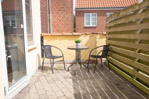 a patio with two chairs and a table with a plant on it at Grindsted - Billund Apartment 1 in Grindsted
