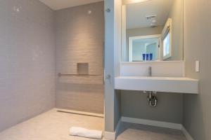 a bathroom with a white sink and a mirror at The Shoals Suites & Slips in Southold
