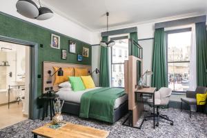 Schlafzimmer mit grünen Wänden, einem Bett und einem Schreibtisch in der Unterkunft Abbey Hotel Bath, a Tribute Portfolio Hotel in Bath