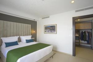 a bedroom with a large bed and a closet at MAIA HOTEL SUITES in Tunis