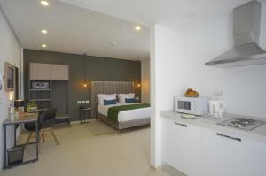 a bedroom with a bed and a kitchen with a microwave at MAIA HOTEL SUITES in Tunis