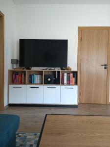 a living room with a television on a white entertainment center at Žvėrynas Workation apartments in Vilnius