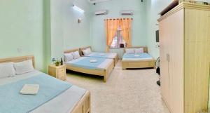 a room with two beds and a window at Minh Huy Hotel in Quang Ninh