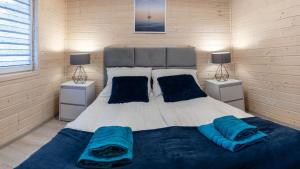 a bedroom with a large bed with blue pillows at Biały Szafir in Rusinowo
