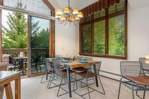 a dining room with a table and chairs and windows at E1 Village Townhouse in Edwards