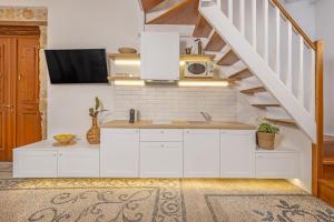 a kitchen with white cabinets and a staircase at Sala Historical Luxury Suites in Rhodes Town