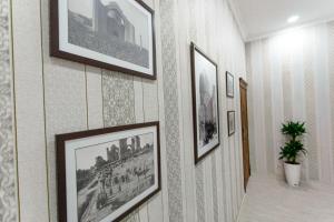 a hallway with framed pictures on the wall at Old Town Samarkand in Samarkand