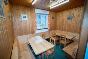 a room with wooden tables and chairs and a window at Pensiun Lischana in Sent