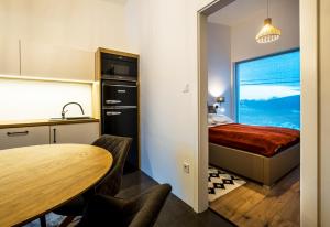 a small room with a bed and a table and a kitchen at EPL Luxury in Eplény