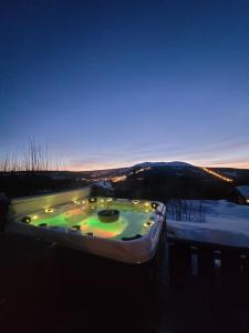 特呂西爾的住宿－ReveEnka - cabin in Trysil with Jacuzzi for rent，雪中带灯光的按摩浴缸