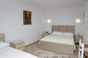 1 dormitorio con 2 camas y un cuadro en la pared en Downtown Apartment 2, en Berat
