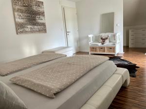 a bedroom with two beds and a chair and a dresser at Ferienwohnung H&H Happy Holiday in Velden am Wörthersee