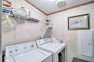 a laundry room with a washing machine and a fan at Greers Ferry Getaway with Deck and Lake Access! in Fairfield Bay