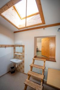 a bathroom with a sink and a skylight at Pensiun Lischana in Sent