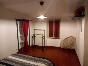 1 dormitorio con 1 cama, 1 silla y 1 ventana en Le Midi 2, en Trèbes