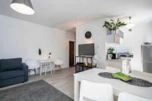 グディニャにある04 Gdynia Centrum - Apartament Mieszkanie dla 4 osのリビングルーム(テーブル、椅子、テレビ付)