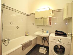 W łazience znajduje się wanna, umywalka i pralka. w obiekcie Apartment Judenplatz by Interhome w Wiedniu