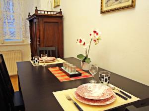 une table avec deux assiettes et un vase avec des fleurs dans l'établissement Apartment Judenplatz by Interhome, à Vienne