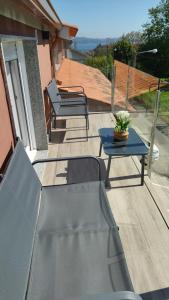 a patio with two chairs and a table on a balcony at Apartamento MARIÑA SANXENXO in Sanxenxo