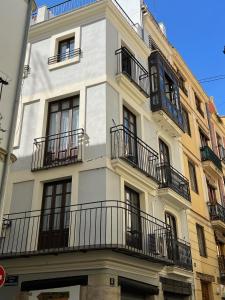 a white building with balconies on the side of it at Plaza Negrito Apartments in Valencia