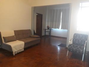 a living room with a couch and a chair at Casa do Peregrino - Confortável no centro in Paraisópolis