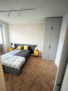 a bedroom with a bed with yellow pillows at Apartament RZ in Gdynia
