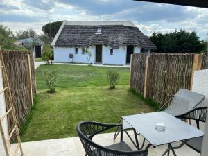 een terras met een tafel en stoelen en een huis bij Hôtel du Pont Blanc in Saintes-Maries-de-la-Mer +47 foto's