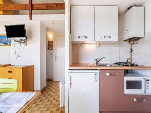 una cocina con armarios blancos y fregadero en Studio Hameau de Pech I-2 by Interhome, en Cap d'Agde