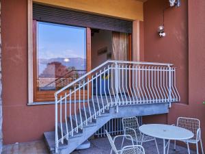 d'un balcon avec un escalier, une table et une fenêtre. dans l'établissement Apartment Hermitage-1 by Interhome, à Porto Valtravaglia