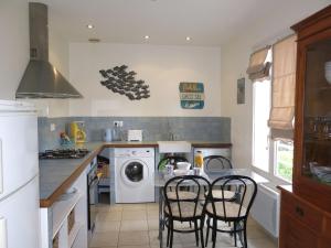 a kitchen with a table with chairs and a washing machine at Holiday Home Monteno by Interhome in Arzon