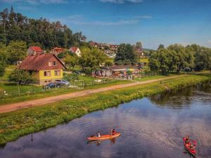 dos personas están en un barco en un río en Holiday Home Lužnice by Interhome, en Koloděje nad Lužnicí