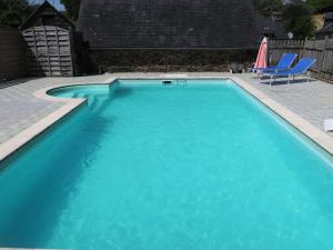 沙托蘭的住宿－斯唐福恩別墅，蓝色游泳池配有两把椅子和一把遮阳伞