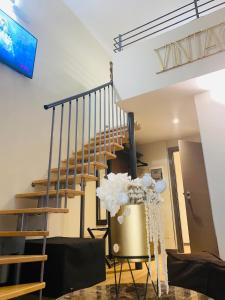 a staircase in a living room with a vase of flowers at INTOMILAN Galleria Duomo I Boutique & Design Aparthotel in Milan