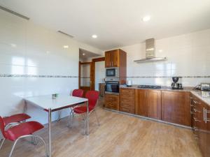 Una cocina con una mesa blanca y sillas rojas. en Holiday Home Eva by Interhome, en Ses Salines