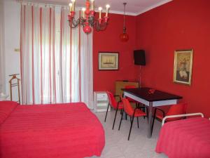 カットーリカにあるApartment Bellavista-1 by Interhomeの赤い壁のベッドルーム(テーブル、椅子付)