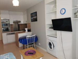 cocina con mesa y TV en la pared en Apartment Le Vieux Port by Interhome, en Cancale