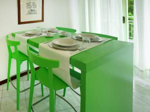 un tavolo verde con sedie e piatti di Apartment Bellavista-7 by Interhome a Cattolica