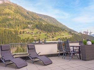 a patio with chairs and a table and a mountain at Apartment Schaller by Interhome in See