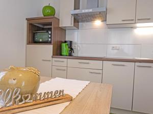 a kitchen with white cabinets and a wooden table at Apartment Schaller by Interhome in See