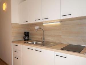 kuchnia z białymi szafkami i zlewem w obiekcie Apartment Barbara - PUT122 by Interhome w mieście Punat