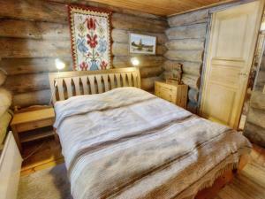 ein Schlafzimmer mit einem Bett in einer Blockhütte in der Unterkunft Holiday Home Hankisääski by Interhome in Ylläsjärvi