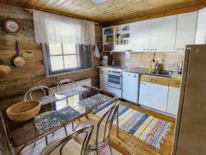 eine Küche mit weißen Schränken und einem Tisch und Stühlen in der Unterkunft Holiday Home Hankisääski by Interhome in Ylläsjärvi + 16 Fotos