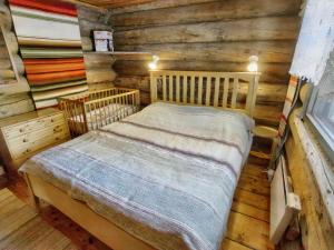 ein Schlafzimmer mit einem Bett in einer Blockhütte in der Unterkunft Holiday Home Hankisääski by Interhome in Ylläsjärvi