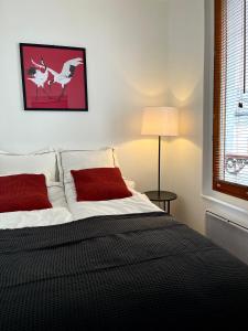 um quarto com uma cama com almofadas vermelhas e uma janela em MaisonZen em Paris