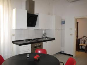 uma cozinha com um lavatório e uma mesa com cadeiras vermelhas em Apartment Bellavista-4 by Interhome em Cattolica