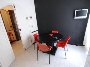 uma mesa preta e cadeiras vermelhas num quarto em Apartment Bellavista-4 by Interhome em Cattolica