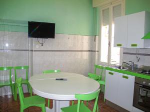 kuchnia z białym stołem i zielonymi krzesłami w obiekcie Apartment Bellavista A by Interhome w mieście Cattolica