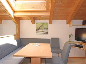 a dining room with a table and a television at Apartment Frischmann-3 by Interhome in Umhausen